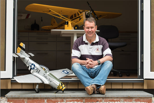 A model aircraft enthusiast sits outside his garden hobby room in Prestbury, Cheshire