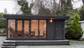 A small black Combi Style Storeroom with glass doors by Rubicon Garden Rooms.