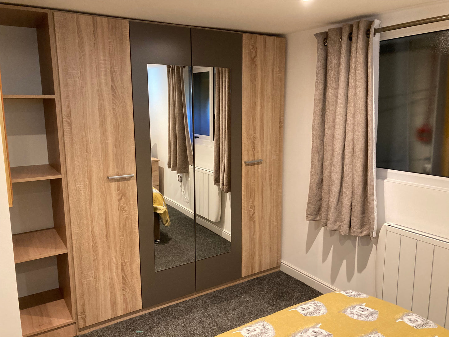 Fully fitted oak veneered wardrobes in the bedroom of a granny annexe