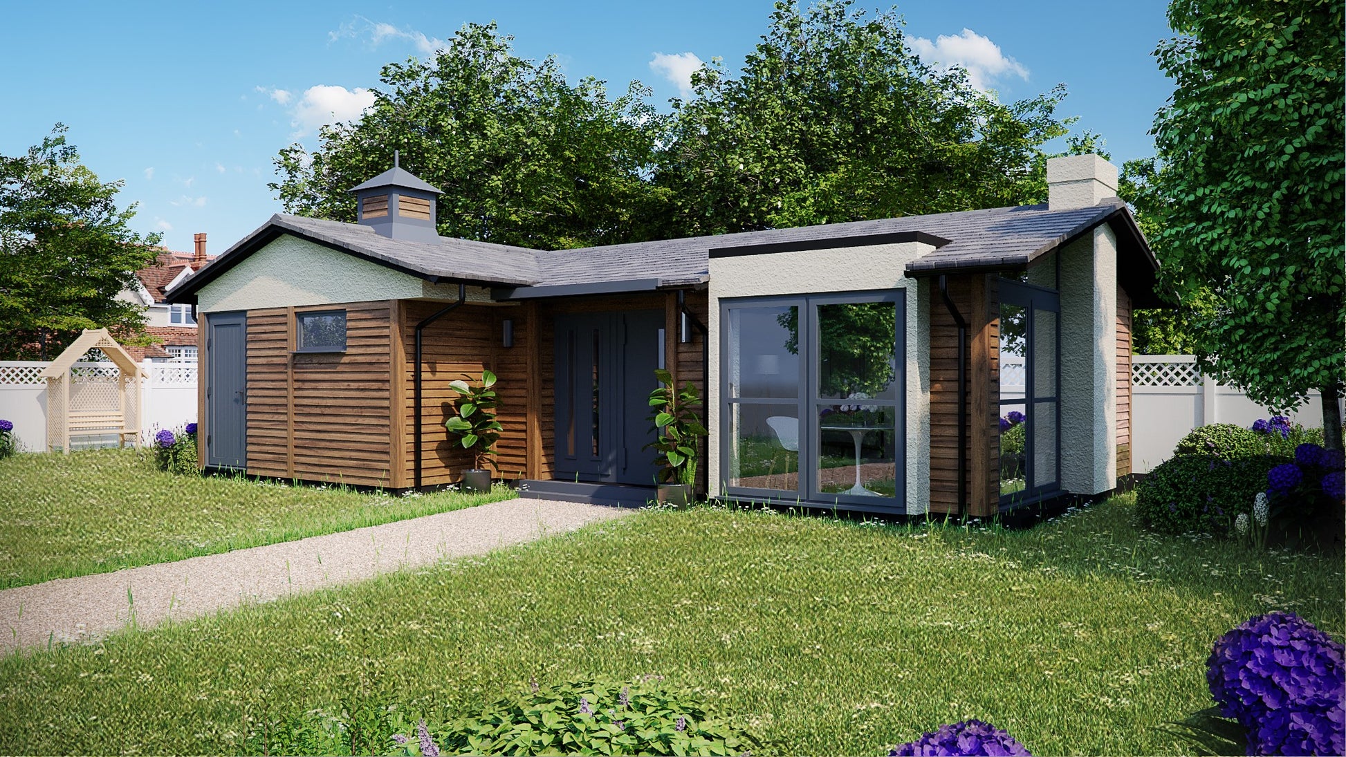Modern Annexe Log Cabin by Rubicon Garden Rooms with large windows, situated in a sunny garden with lush grass and flowering shrubs.