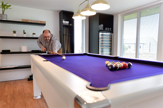 A man playing billiards in a living room.