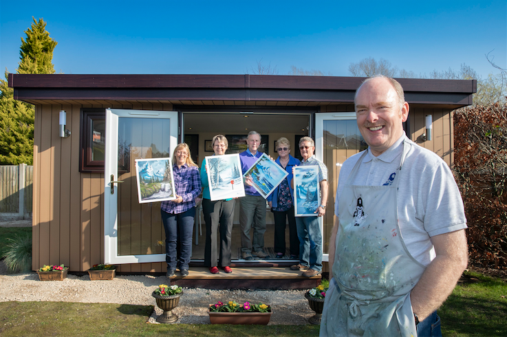 A group of people standing in front of a garden room office in Chester .