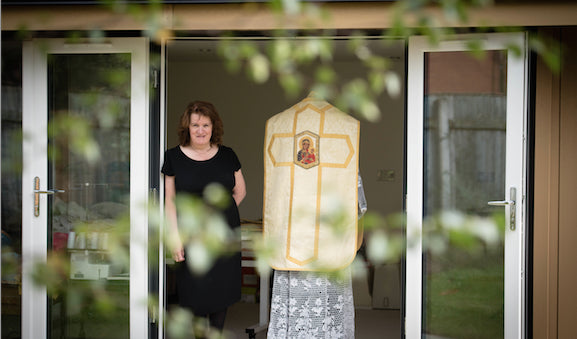 A woman in a black dress standing in front of a door.