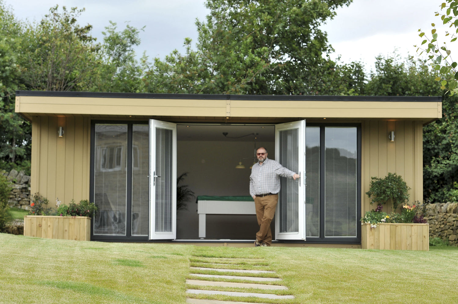 A composite garden room office in Wrexham, North Wales with matching flower pots