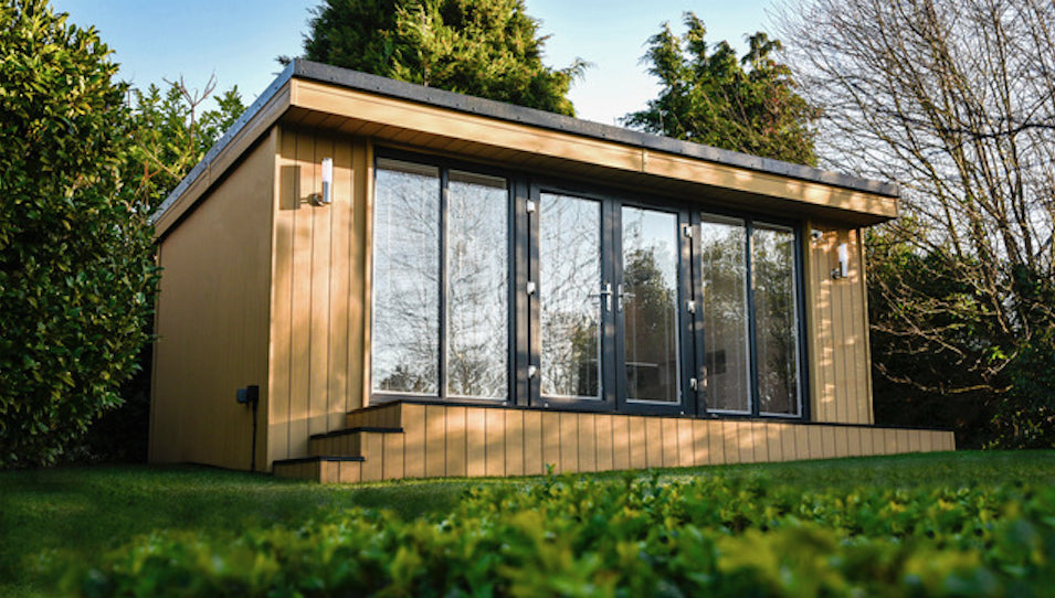 A garden shed in the middle of a grassy area.