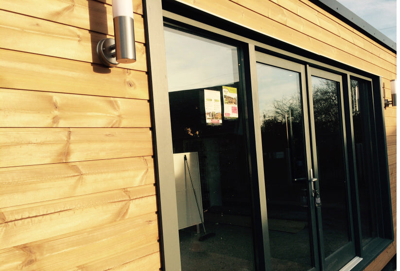 A wooden shed with a sliding glass door.