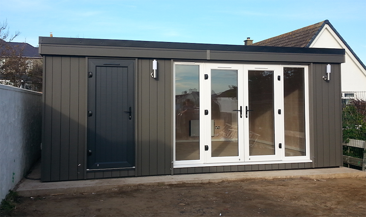 A grey shed with a door and windows.