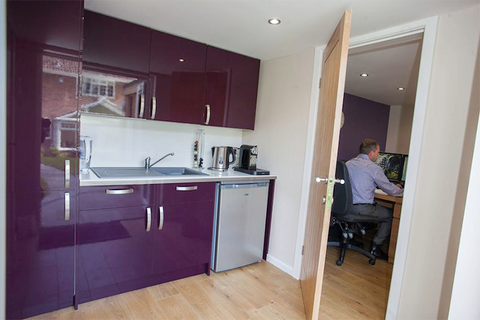 A garden room office with a kitchen and fridge