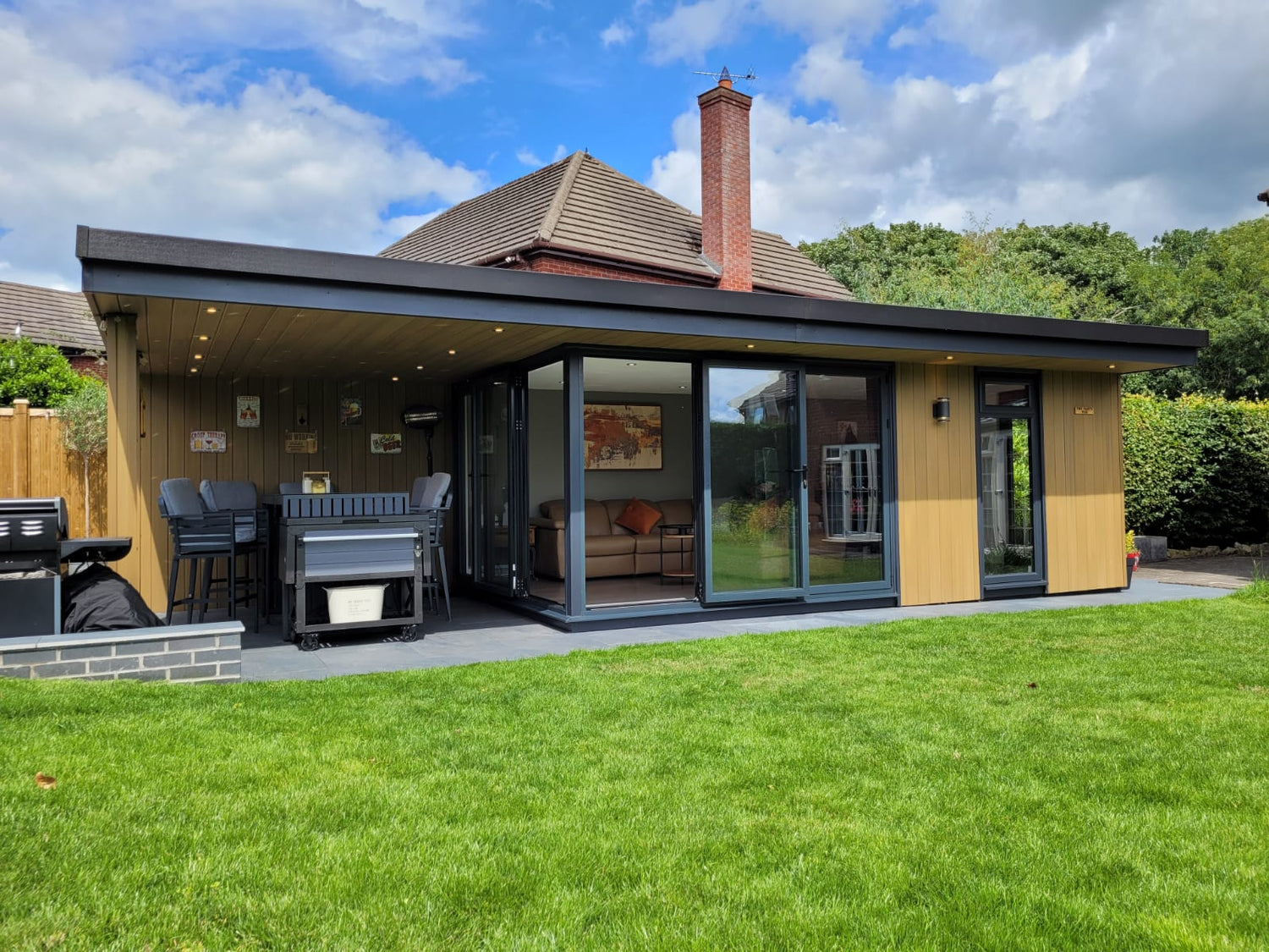 A large garden room with bi-fold doors and large side canopy in Manchester