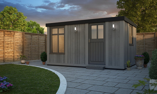 An image of a Cabin Style garden shed with plastered interiors by Rubicon Garden Rooms in the evening.