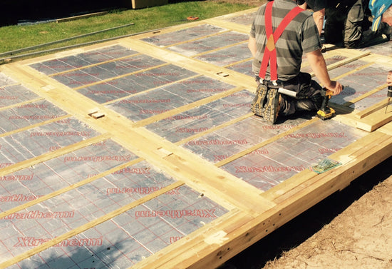 A group of people working on a wooden deck.