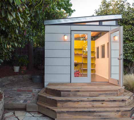 A small backyard shed with a yellow door.