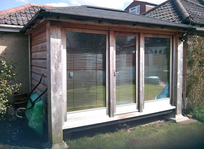 A wooden shed with a glass door.