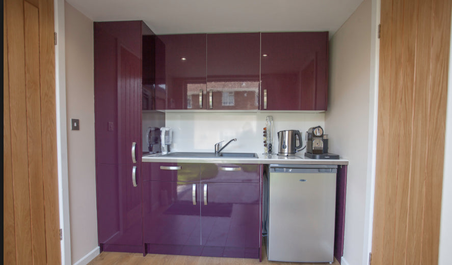 A purple kitchen in a small room.