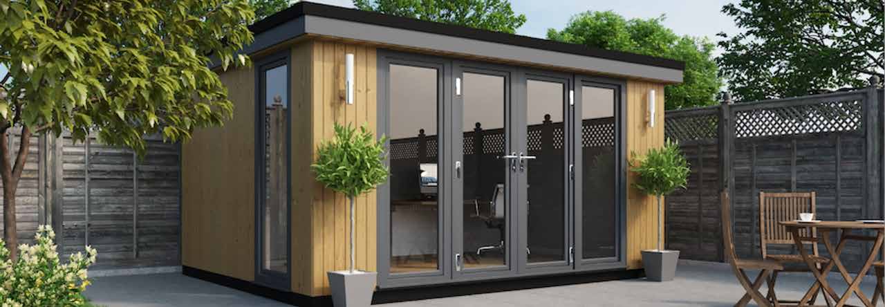 A garden office with a table and chairs.